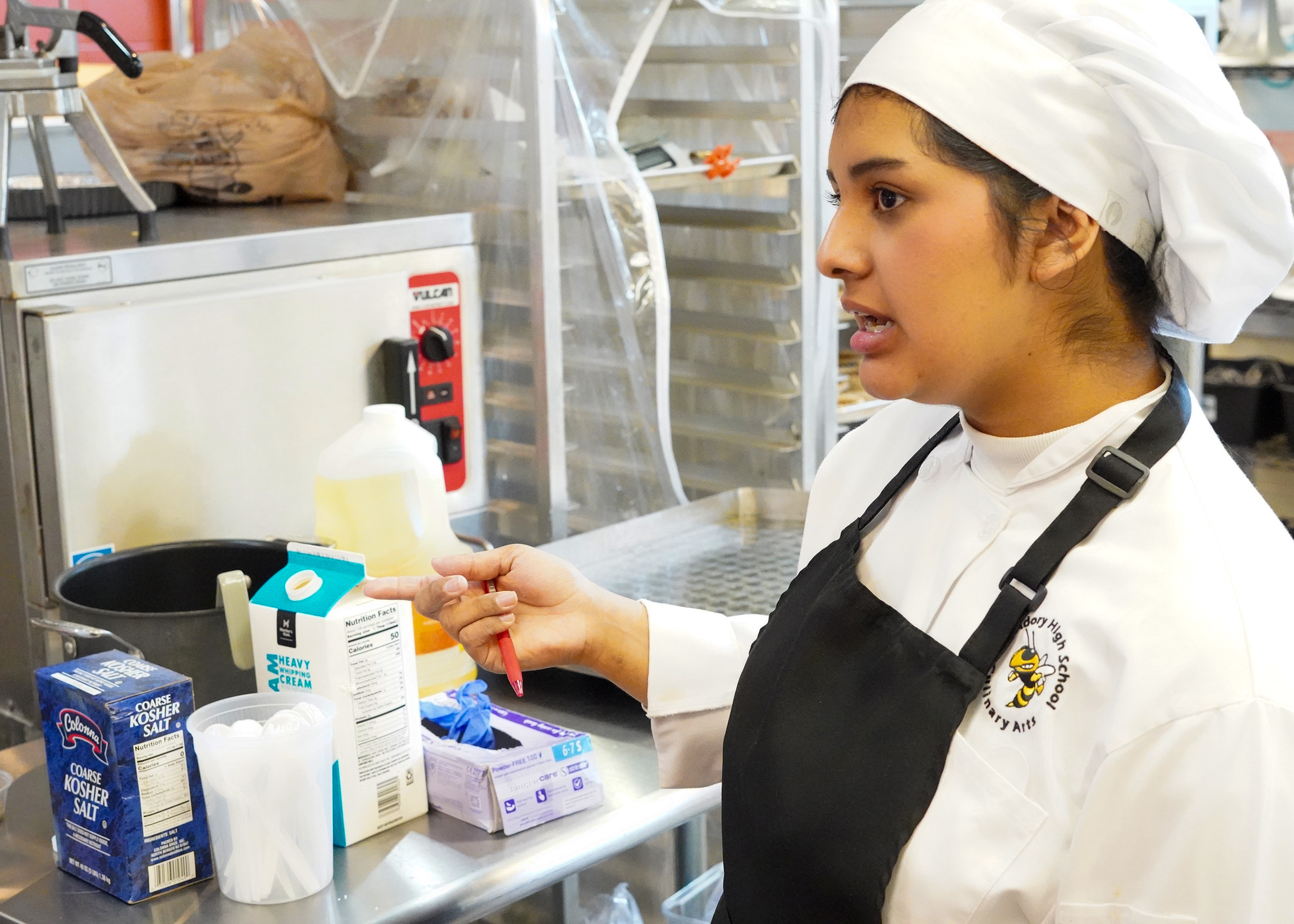 Female student is working in the kitchen to serve lunch as part of the culinary arts program. 