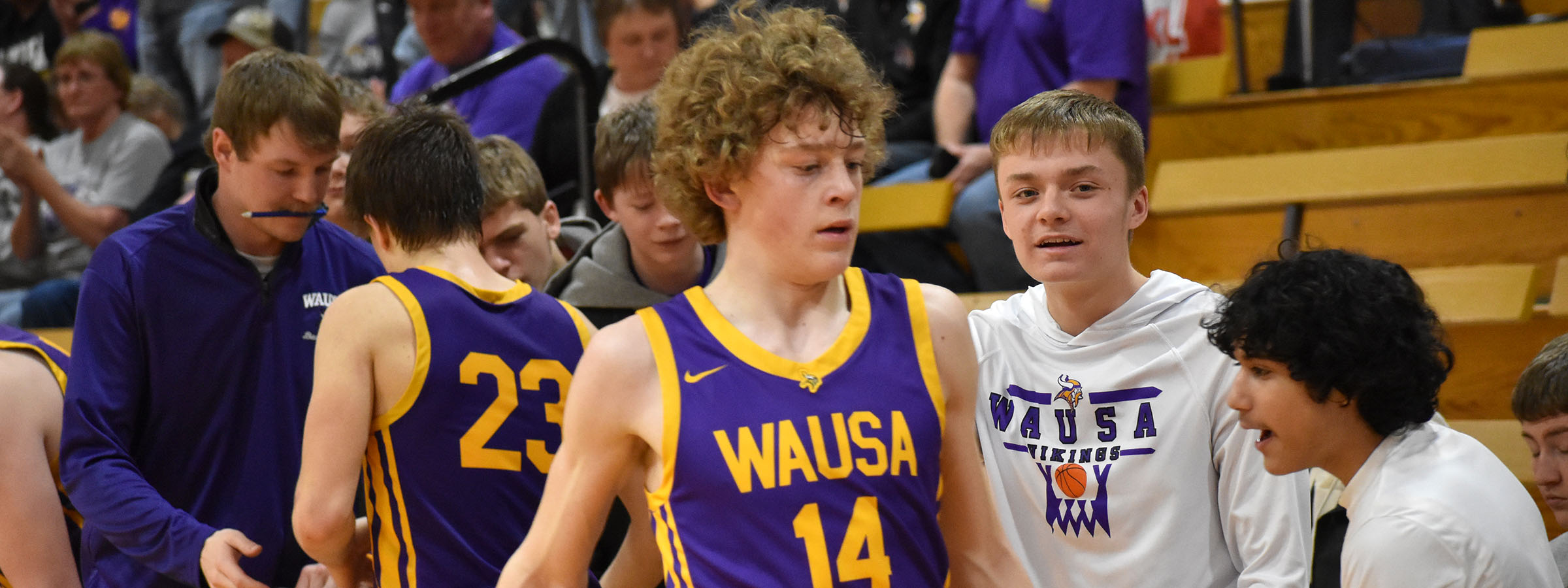 A group of boys in purple and gold uniforms standing together.