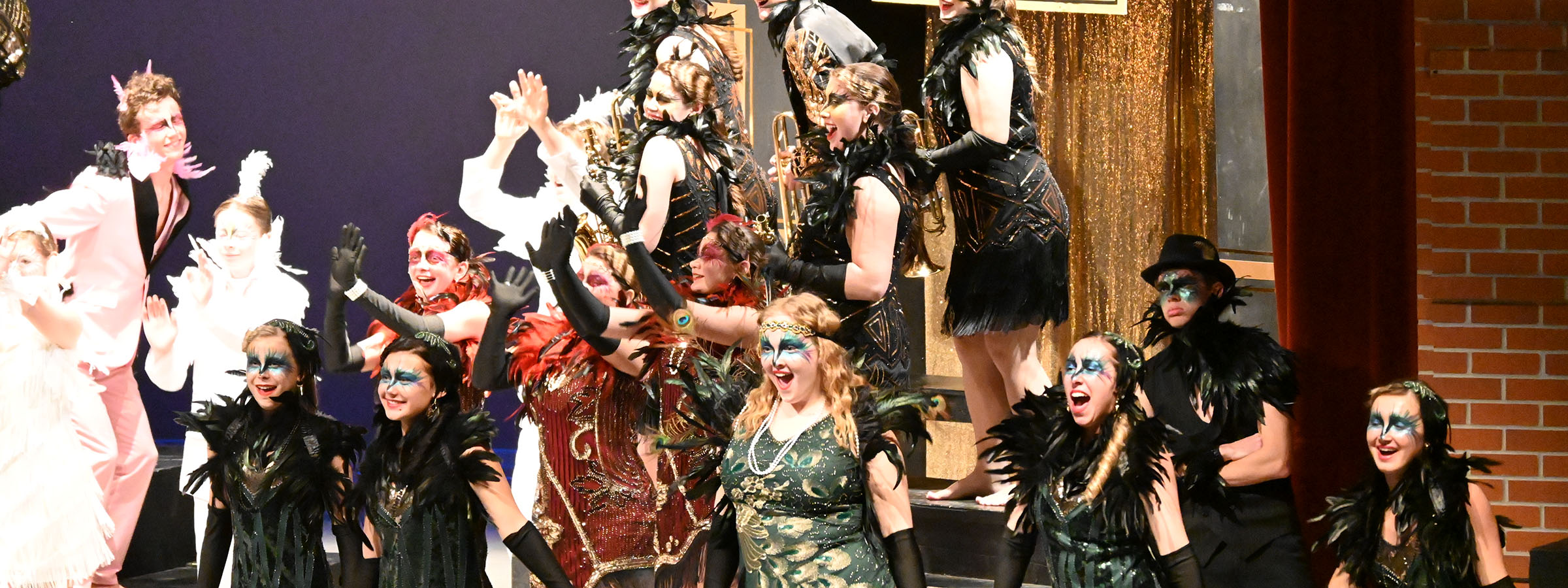 Several individuals in colorful costumes performing on a stage.