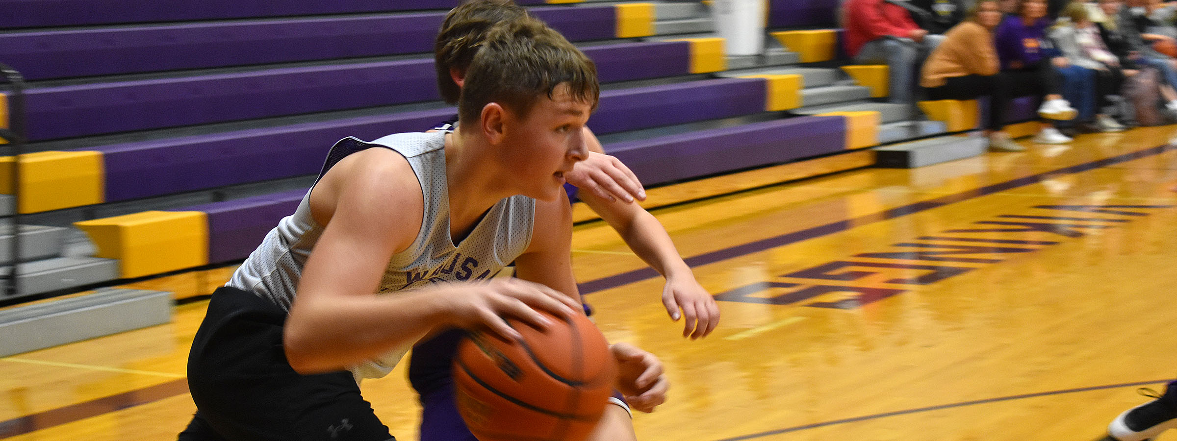  Young boy skillfully dribbling basketball on outdoor court.