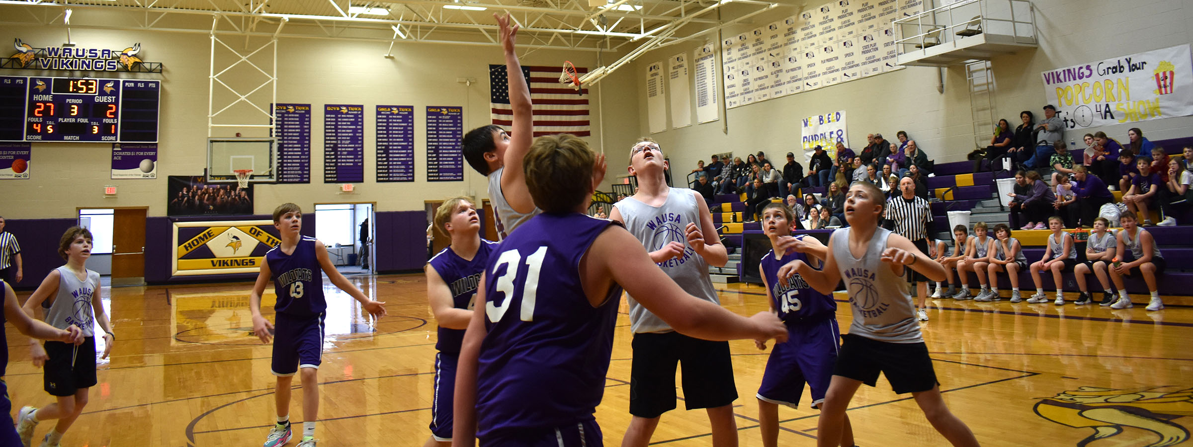 Boys playing basketball in a gym, dribbling and shooting hoops, having fun and staying active.