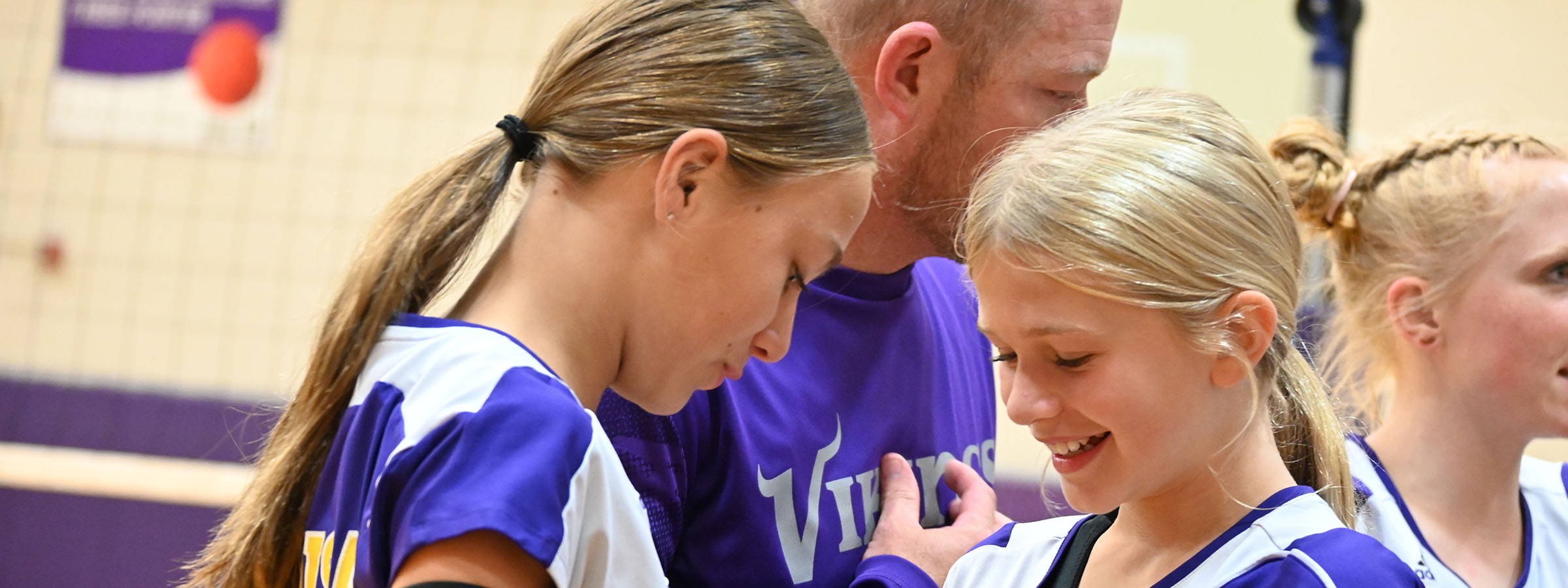 A group of female volleyball players huddled together on the court, strategizing during a game.