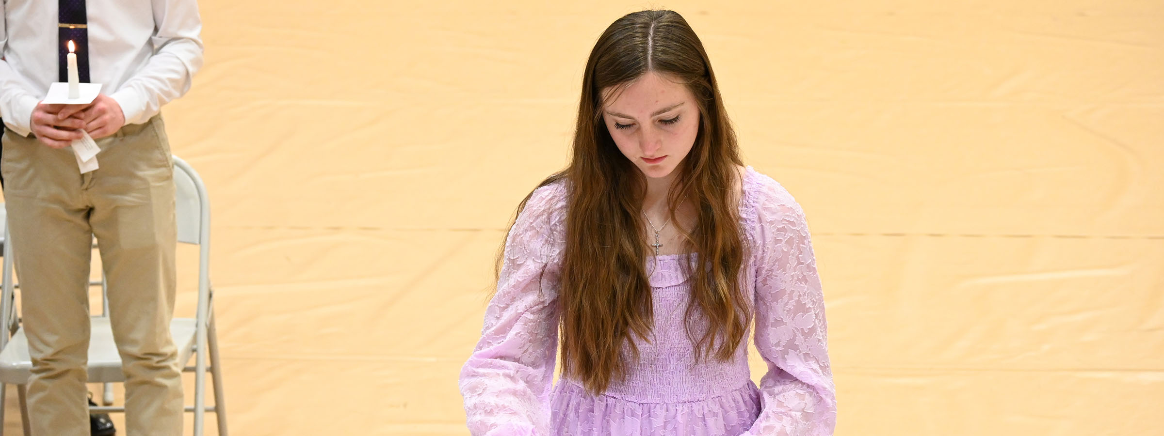 A girl in a purple dress holding a white board.