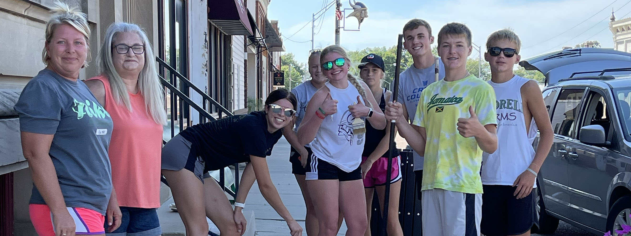  A group of friends smiling for a photo on the sidewalk.