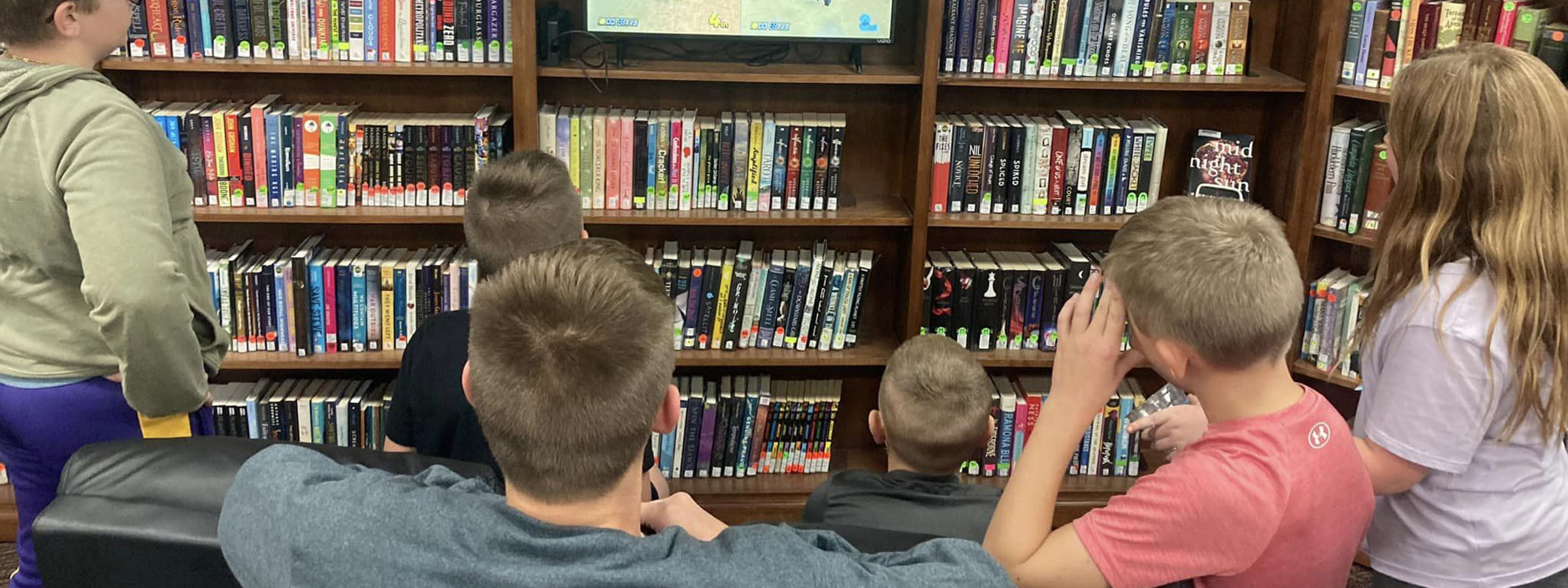  Children watching TV in library.