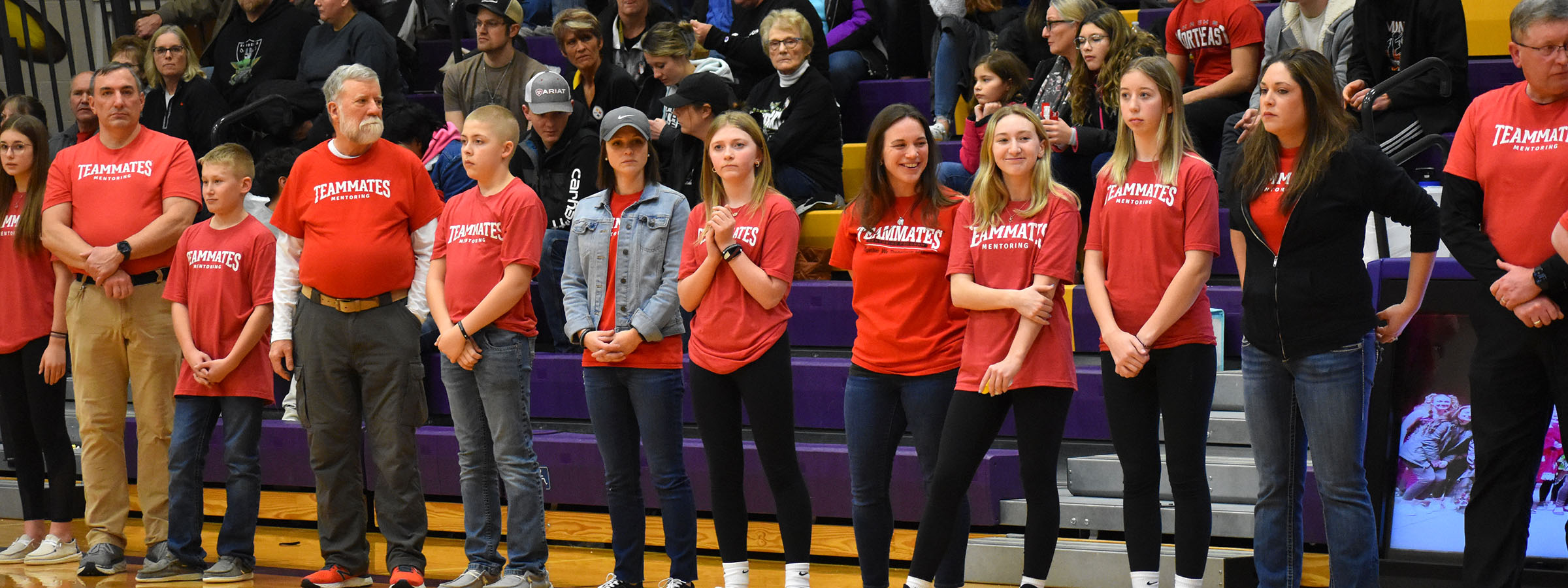  A diverse group of people standing on a basketball court, ready to play a game together.