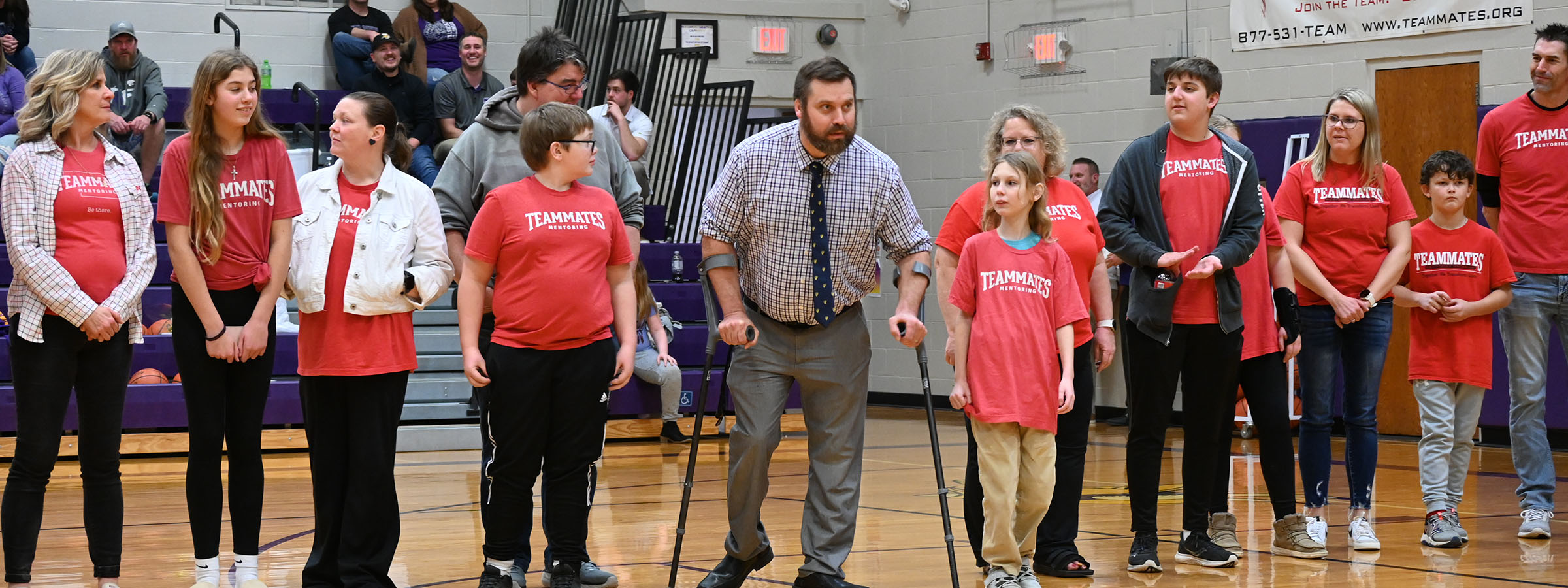  A diverse group of people standing on a basketball court, ready to play a game together.