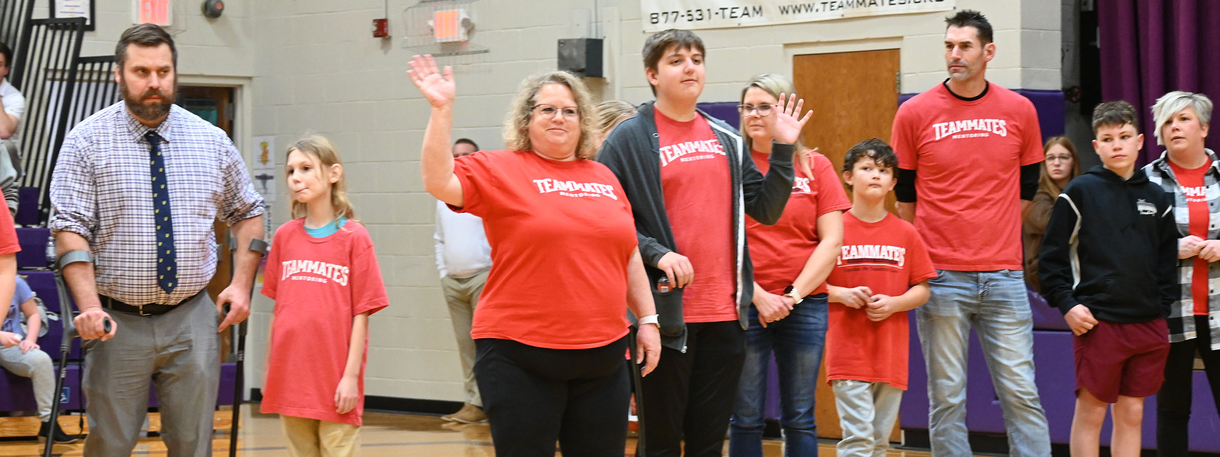 A group of people in red shirts standing in a gym.