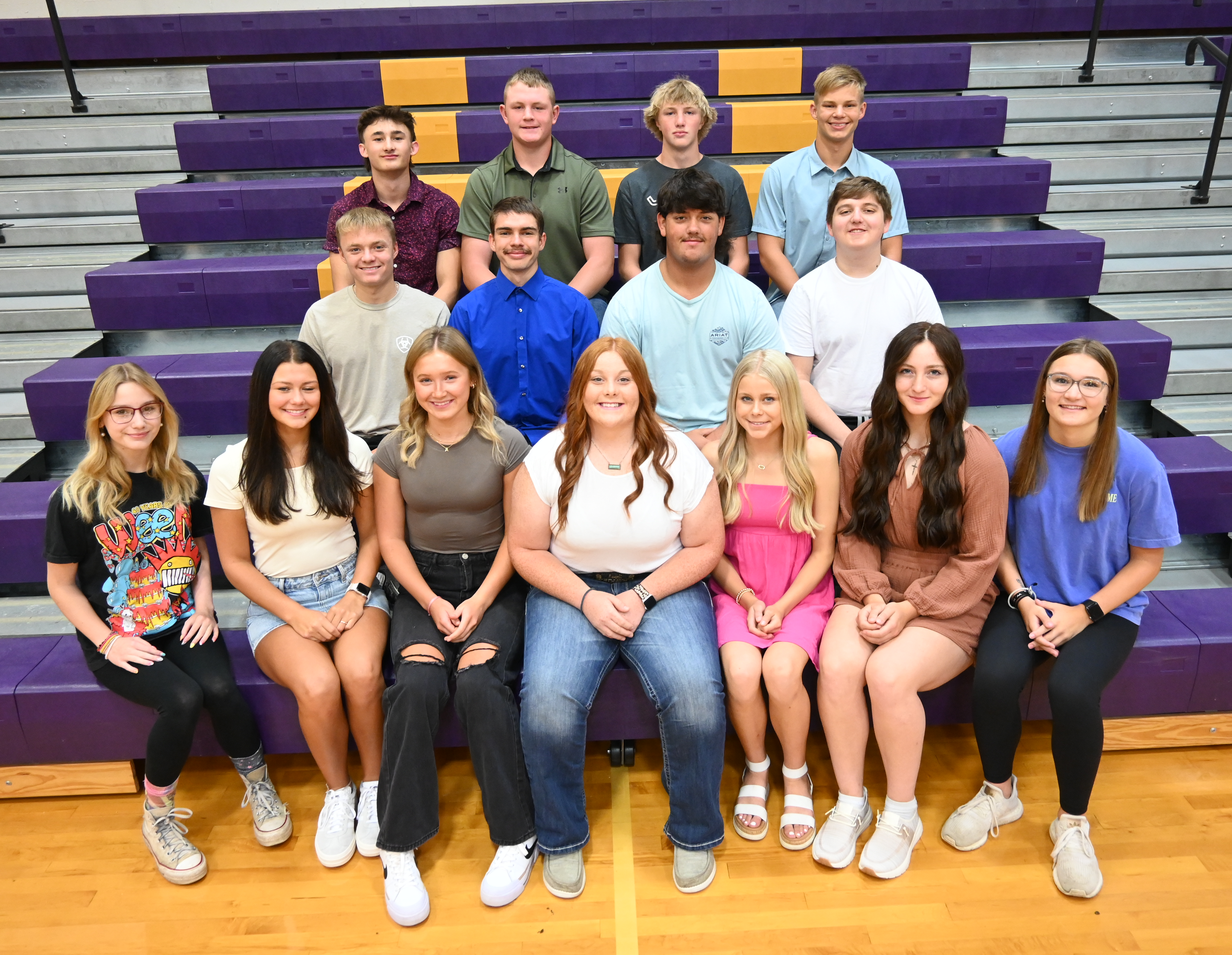 A diverse group of young individuals sitting on bleachers, chatting and laughing together.