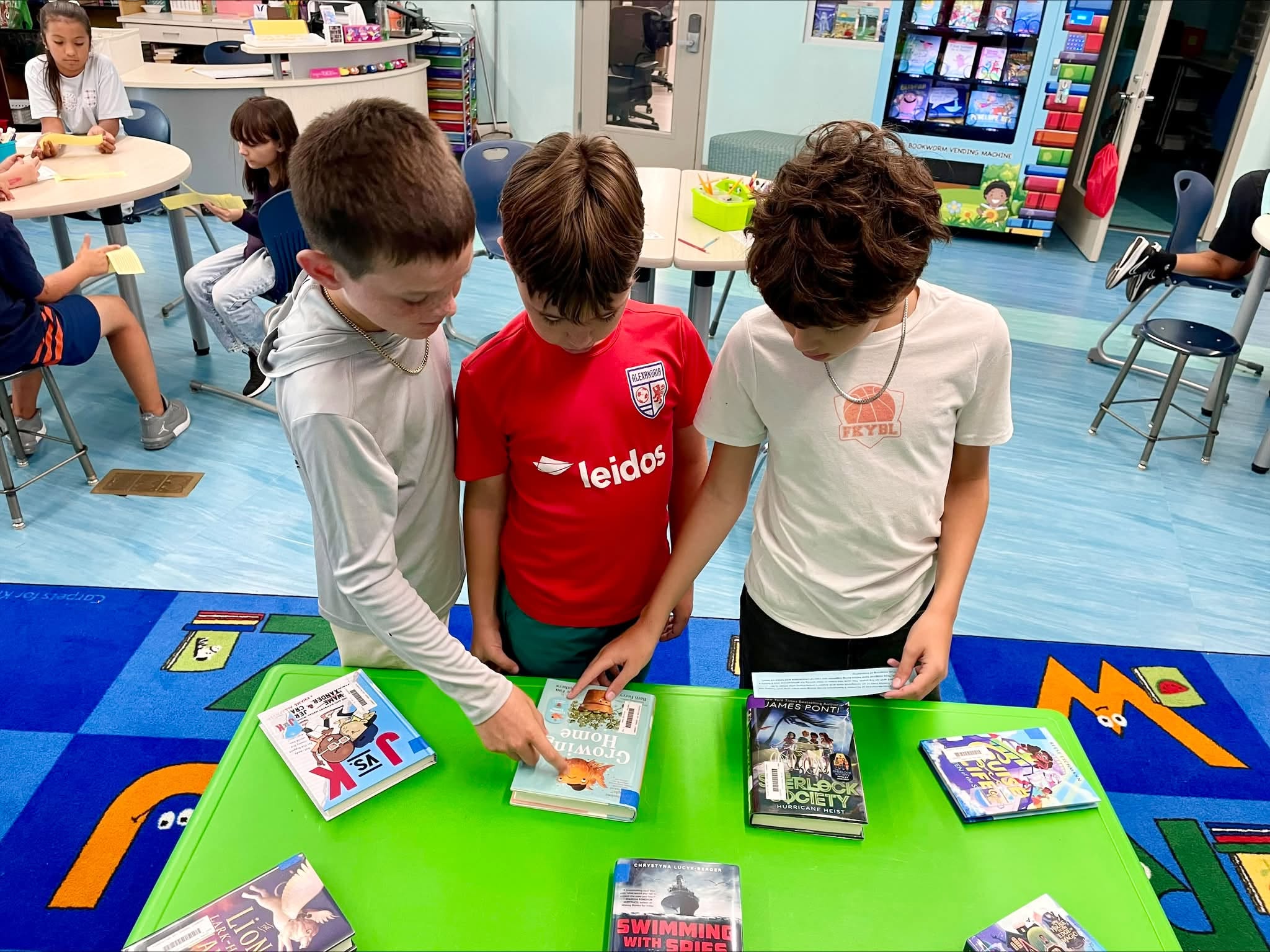 Three boys looking at books