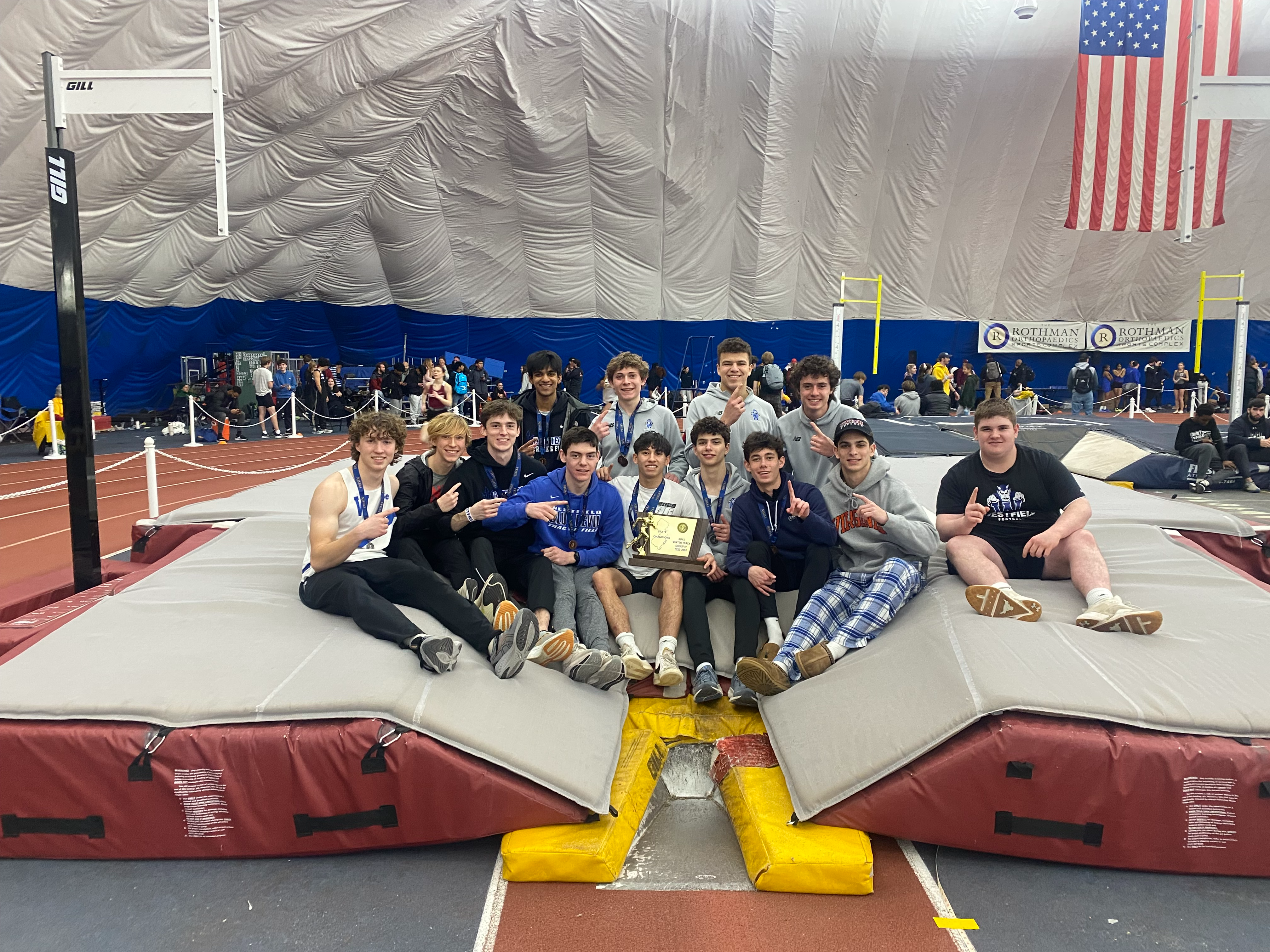 Track athletes  in a group picture with trophy