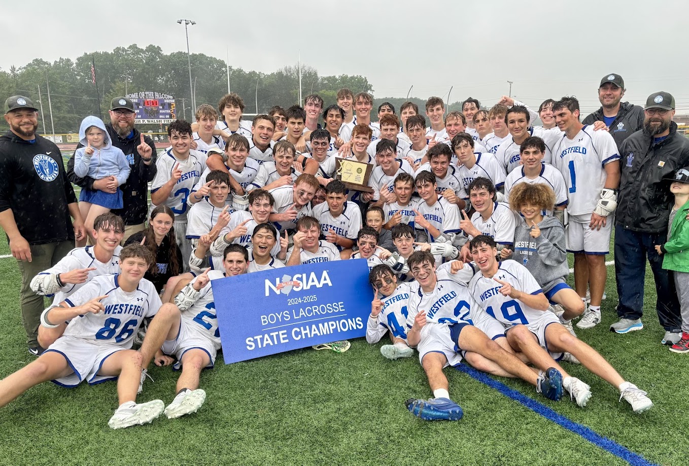 Boys on a turf field holding a trophy