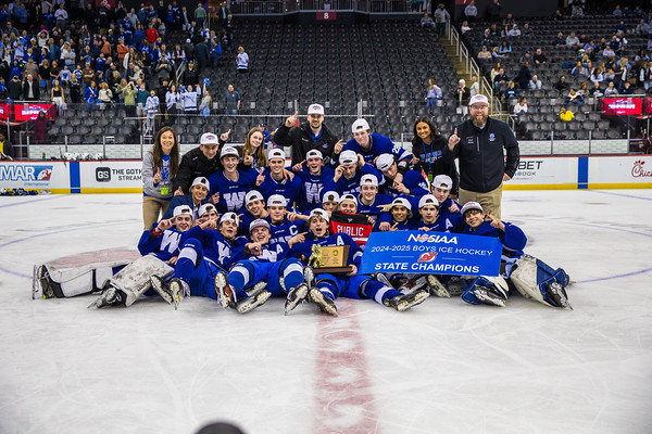 Boys on ice rink holding a trophy