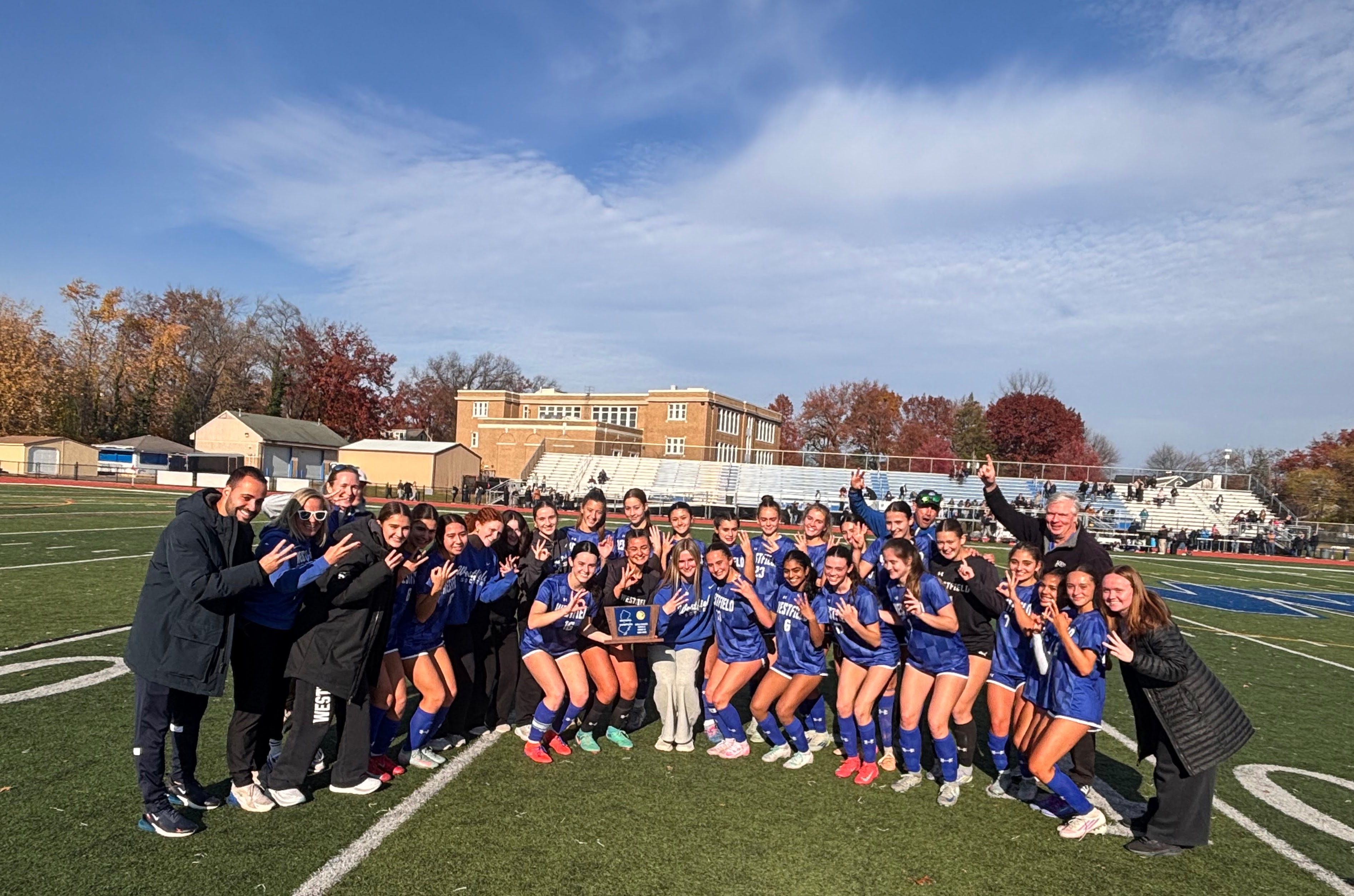 Girls on soccer field holding a trophy