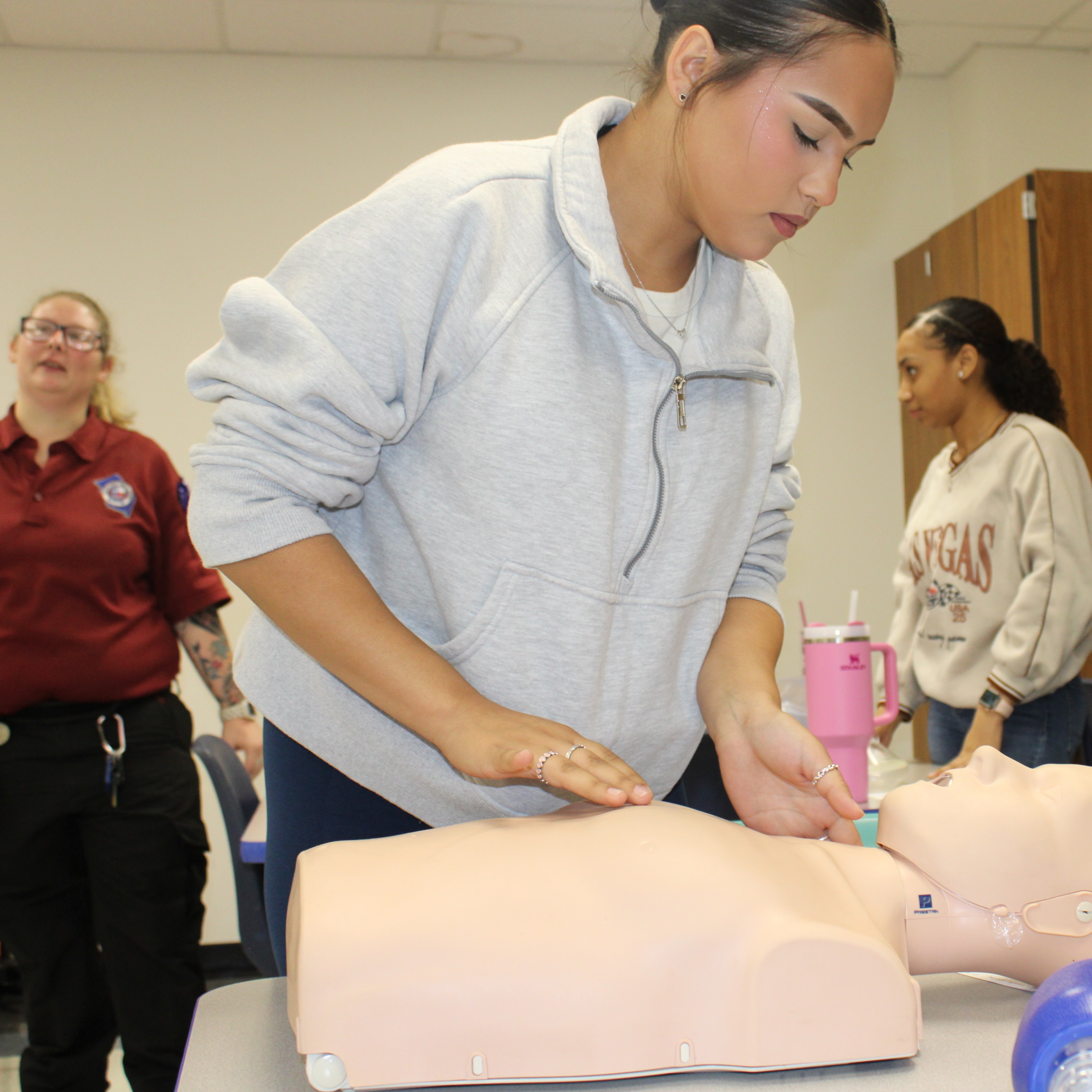 Student practicing CPR with the assistance of an instructor