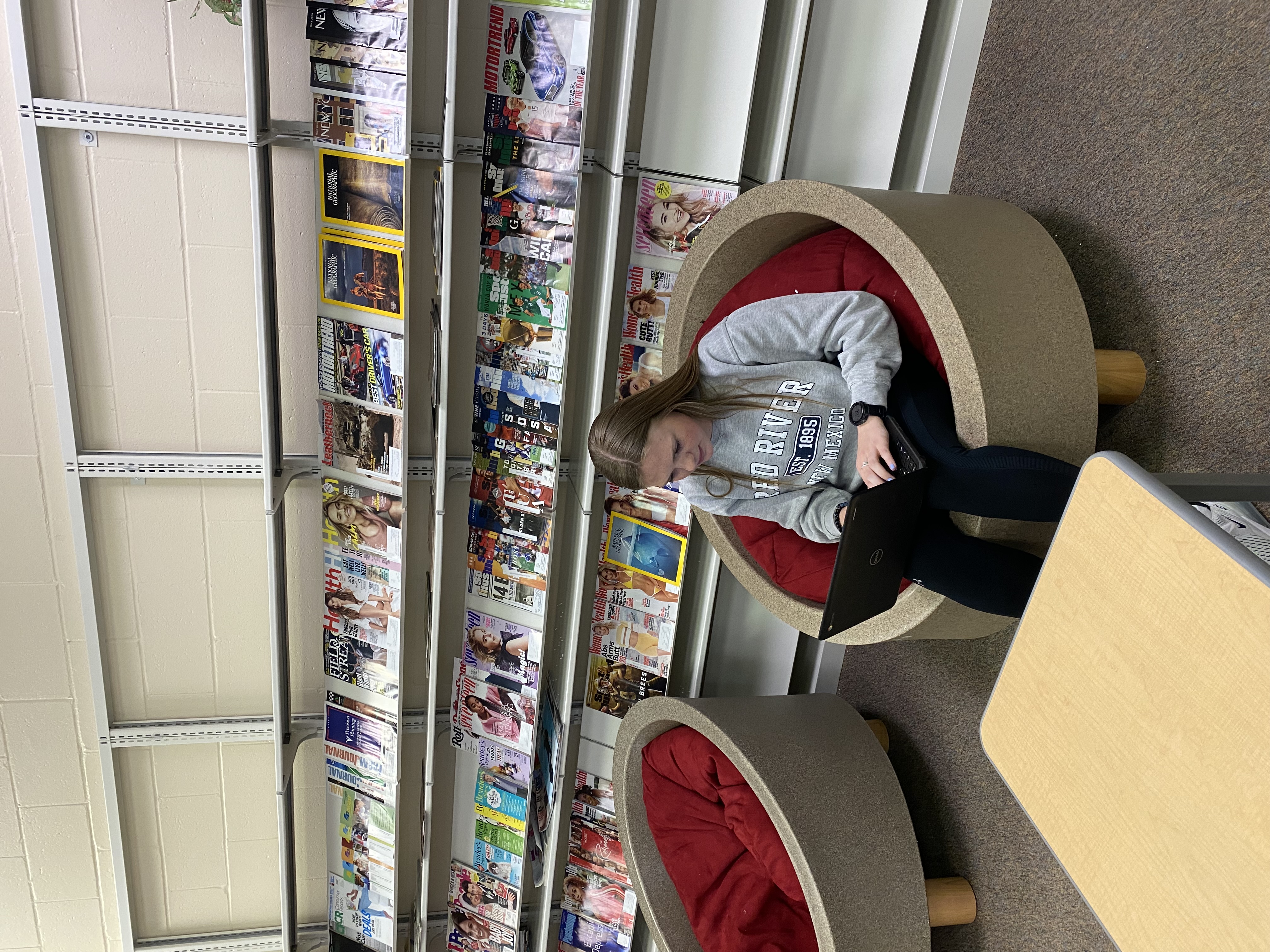 girl sitting on cushion reading book