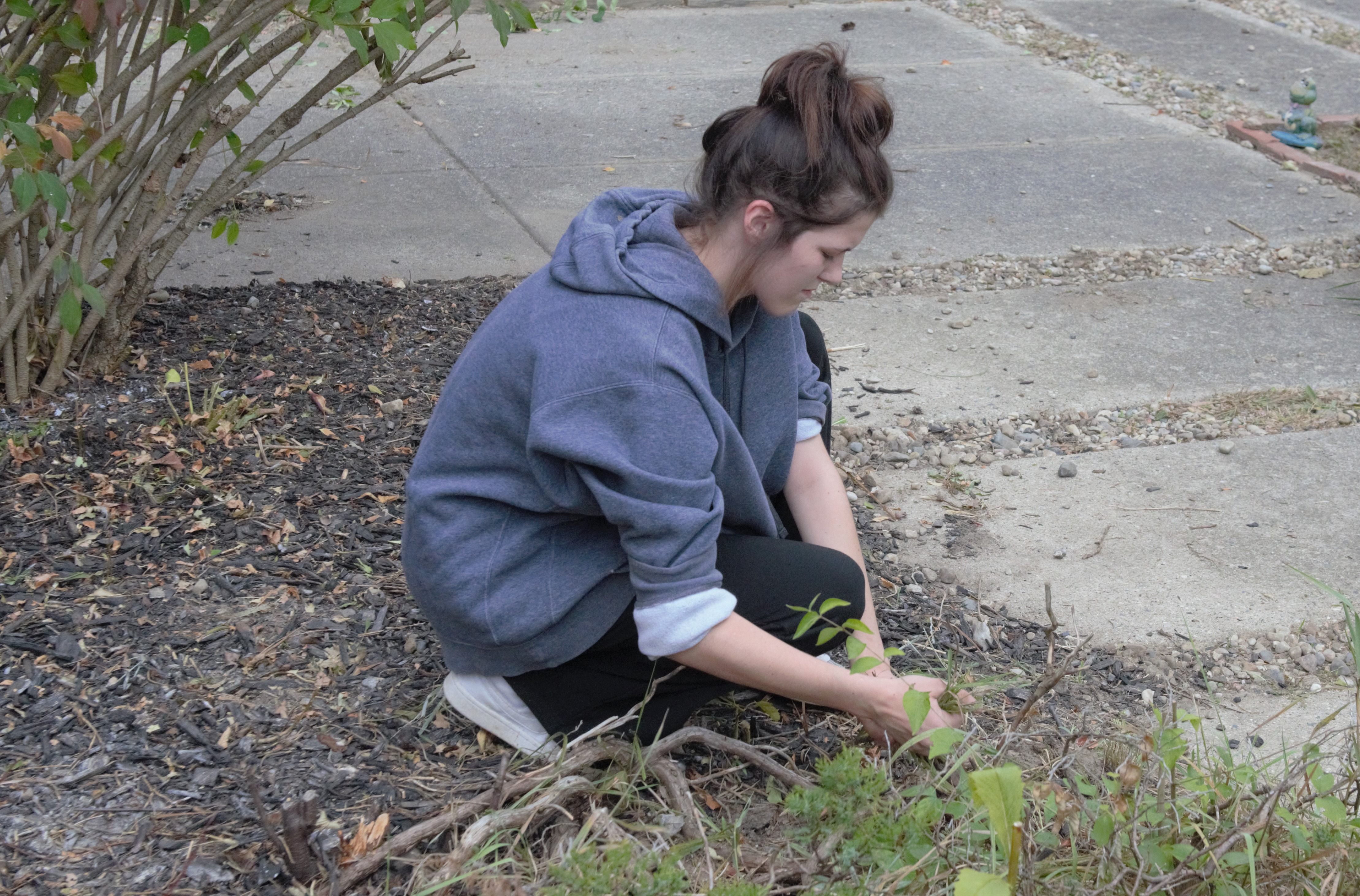 student cleaning up in courtyard