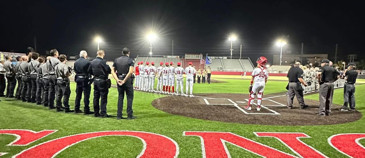 Baseball field with ball players and first responders