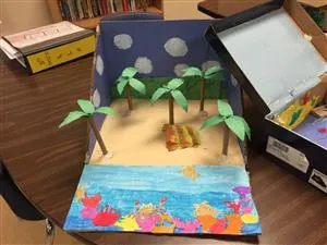 A cardboard box with a beach scene inside of it