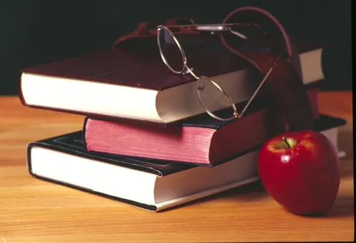 A stack of books with a pair of glasses on top of them