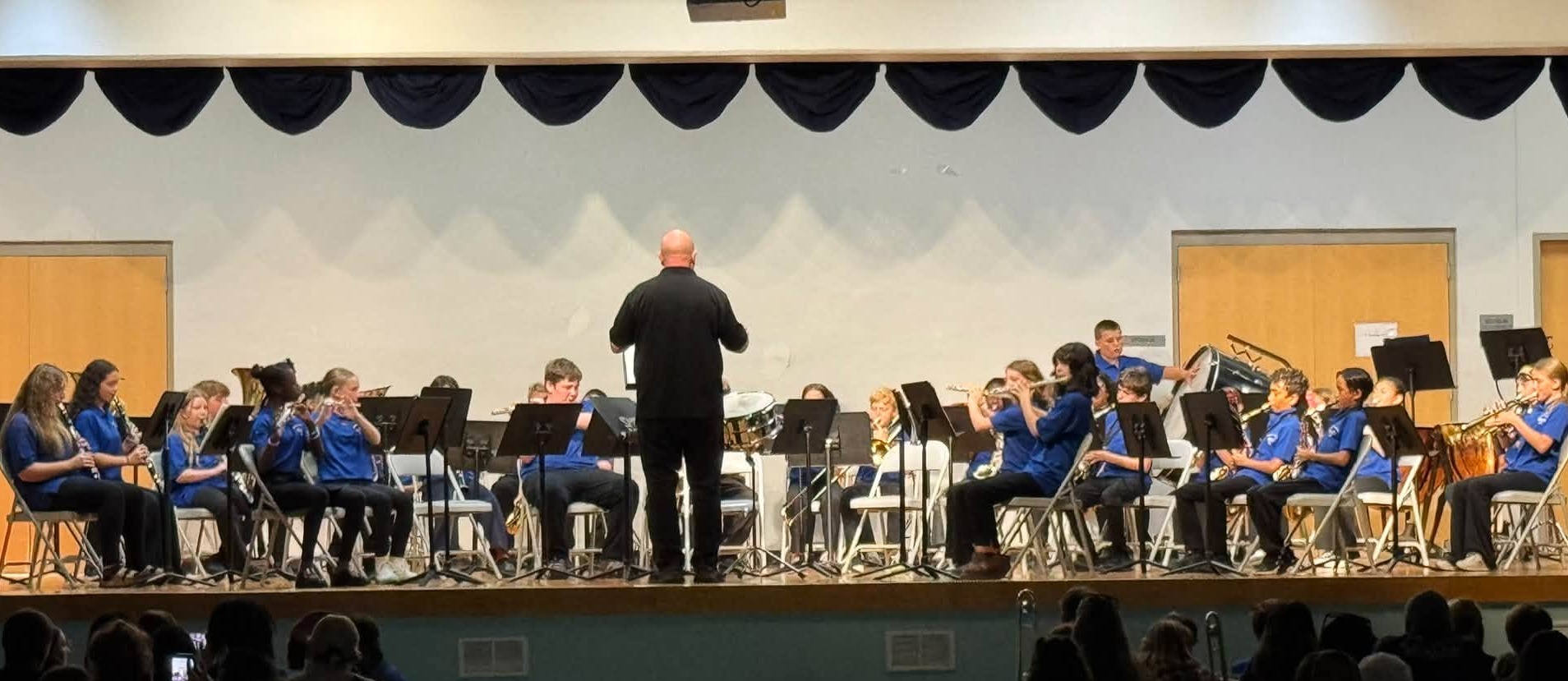 Band playing at concert with band director in front