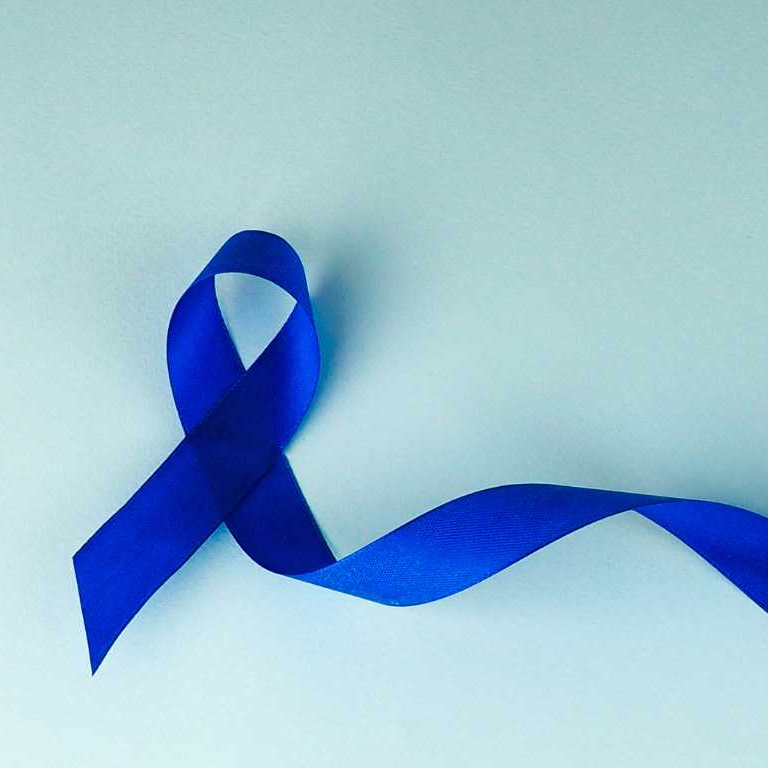 A blue awareness ribbon is displayed against a light background, symbolizing support for various causes.