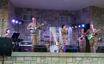 A group of soldiers joyfully playing music on stage