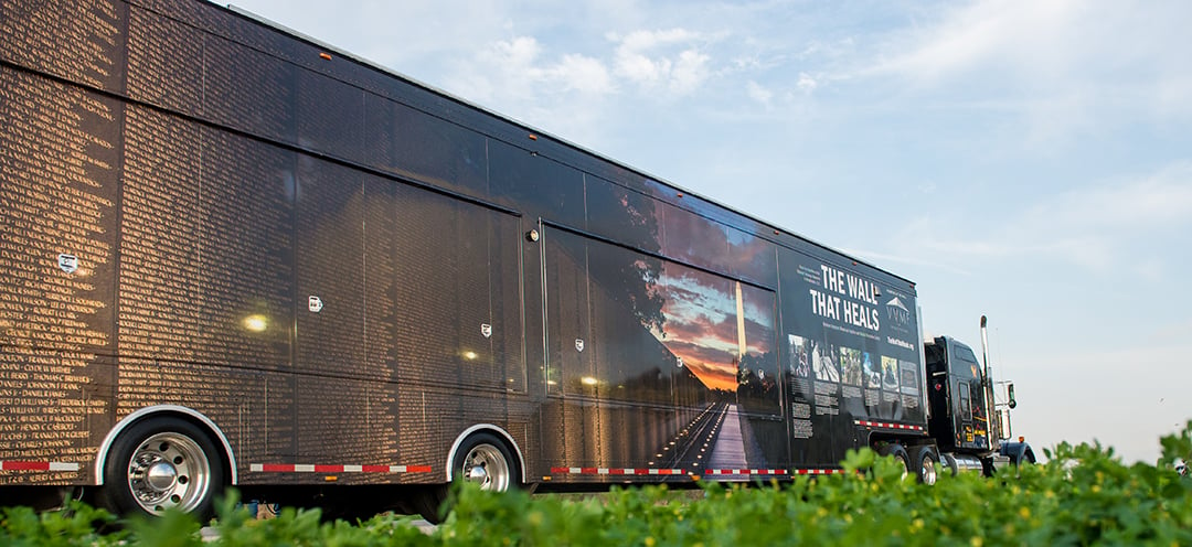 A large semi truck with a colorful billboard on its side