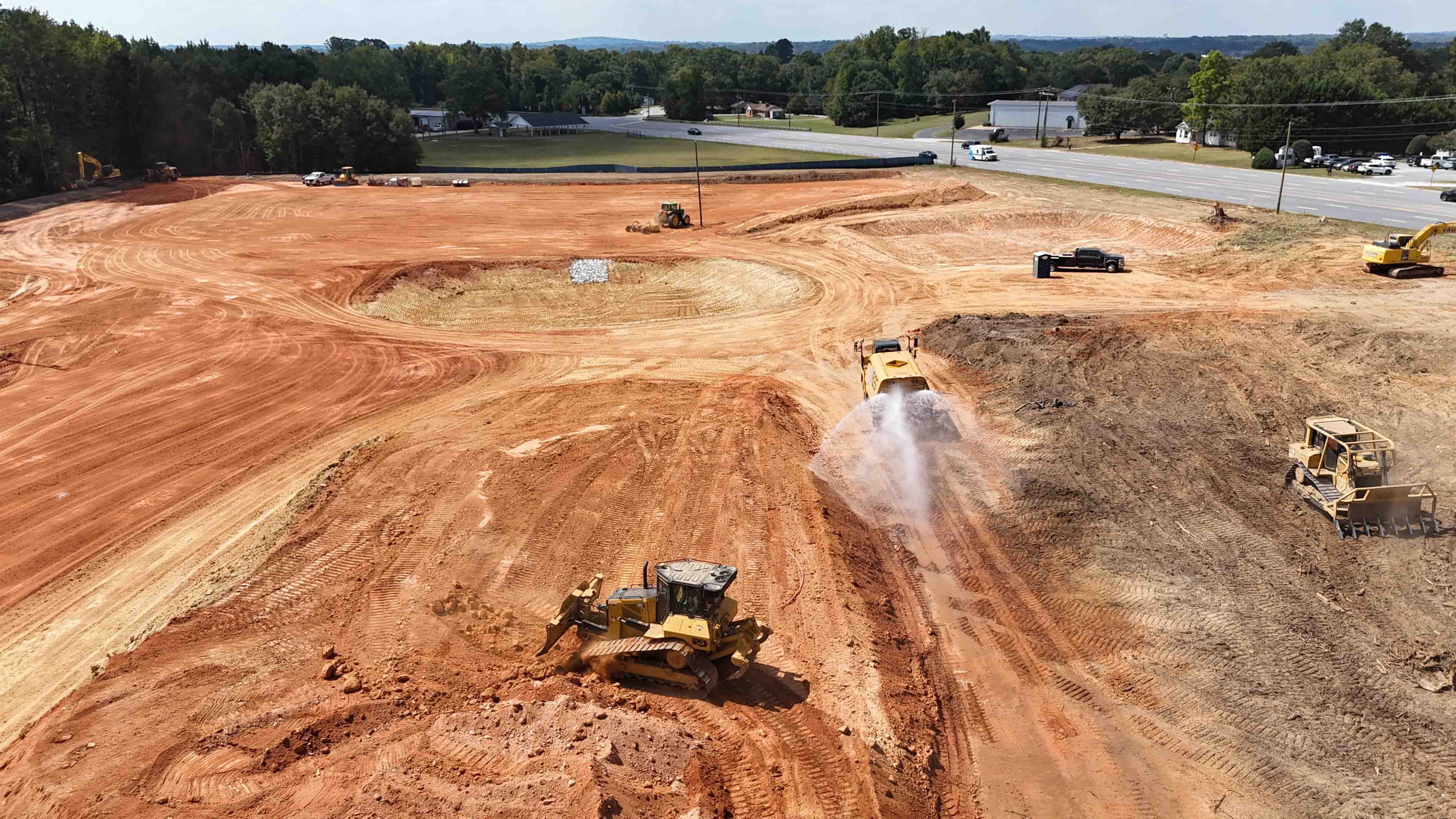 Sports and Events Center Construction Site with Water Truck and Other Equipment