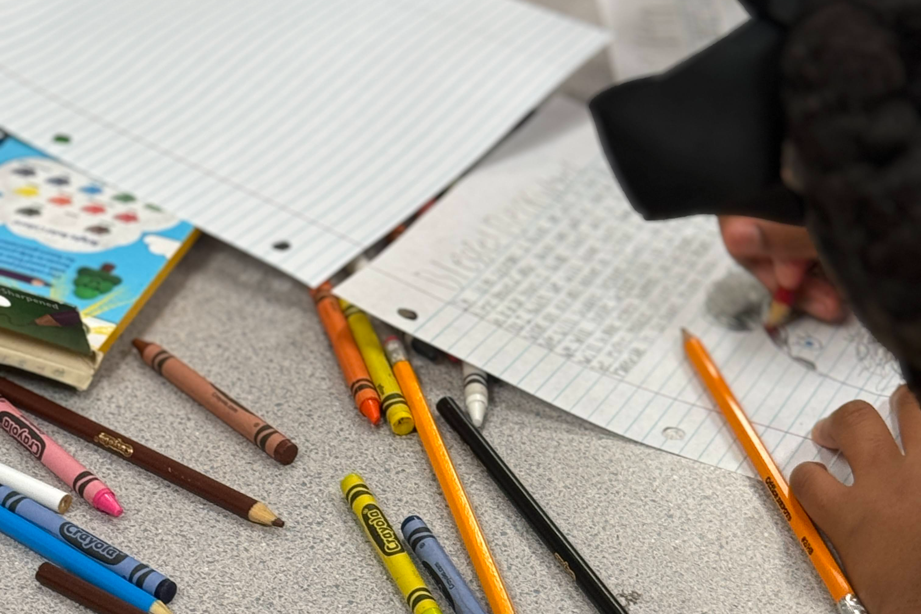 student writing in a notebook