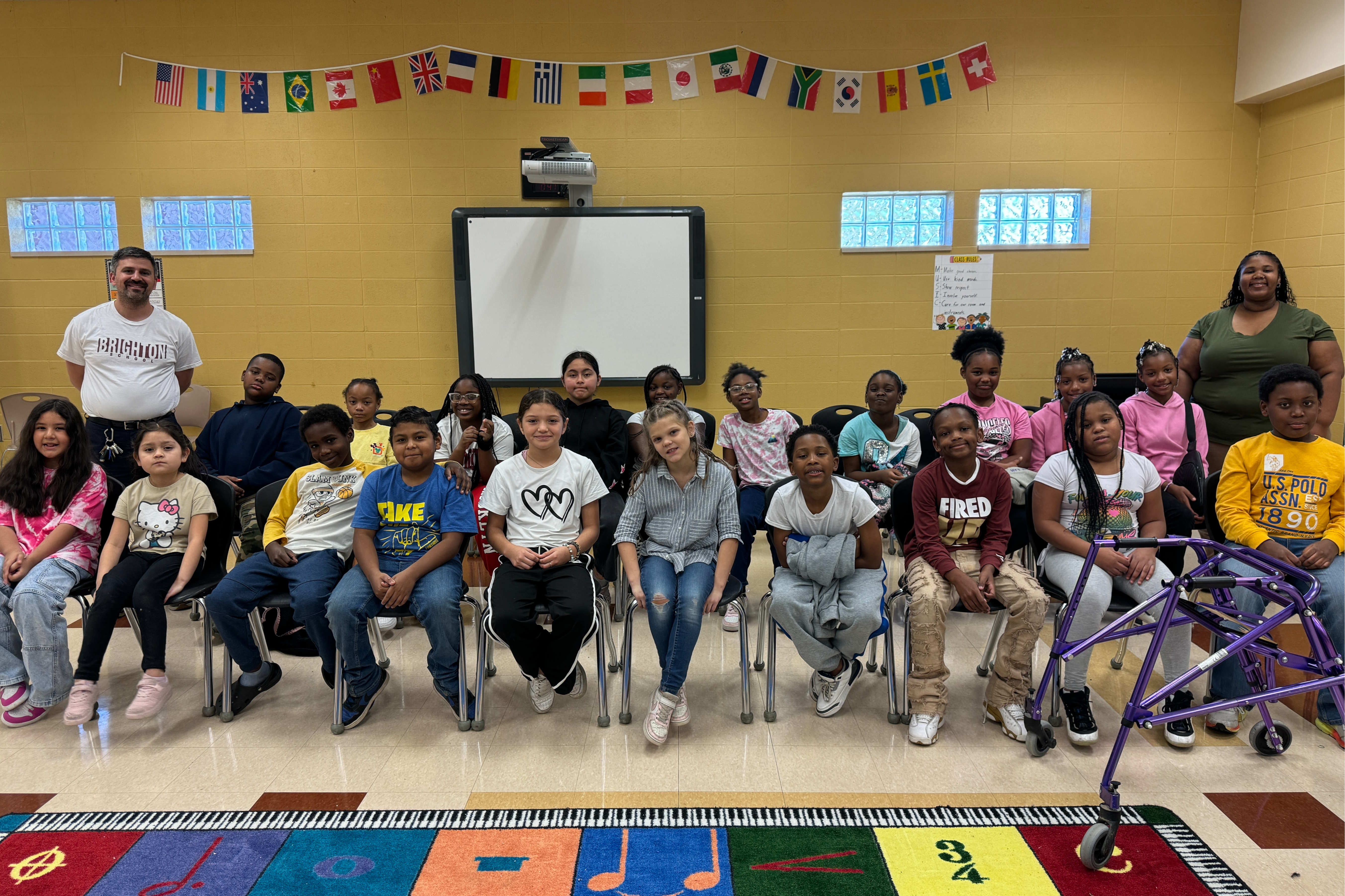 students and two teachers sitting in the music room at Brighton