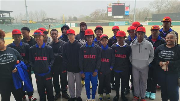 A team of young baseball players poses for a group photo before their game.