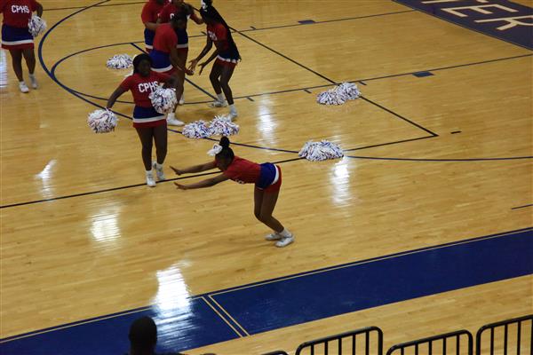 A group of cheerleaders practicing in a gymnasium.