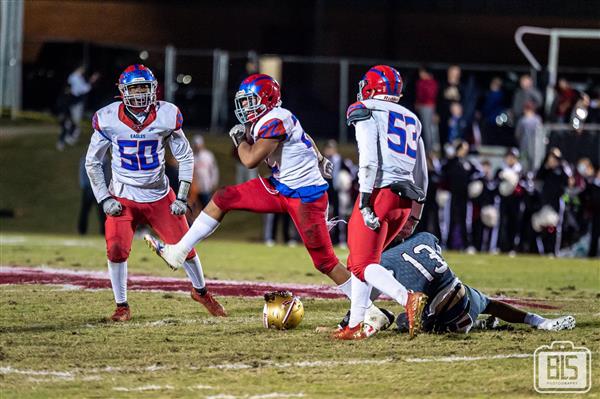 Two teams of football players on the field, one player from each team in action.