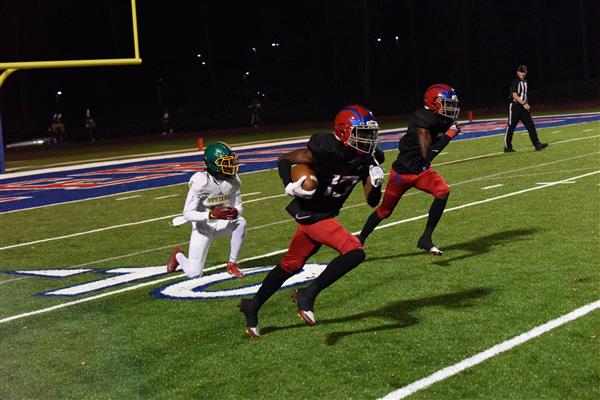 Football players running in a field.