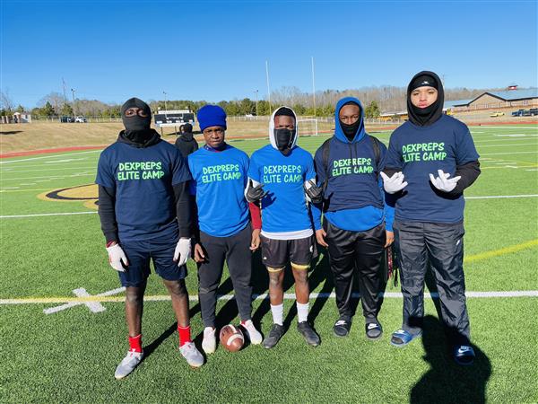 A group of football players posing for a photo on the field.