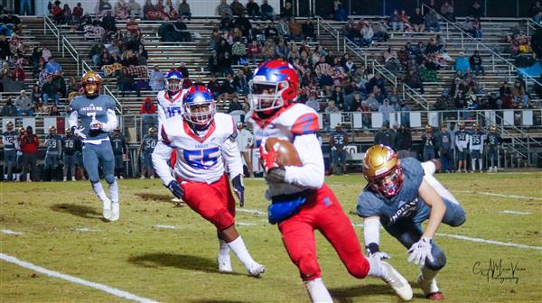 A young athlete in action on a football field during a game.