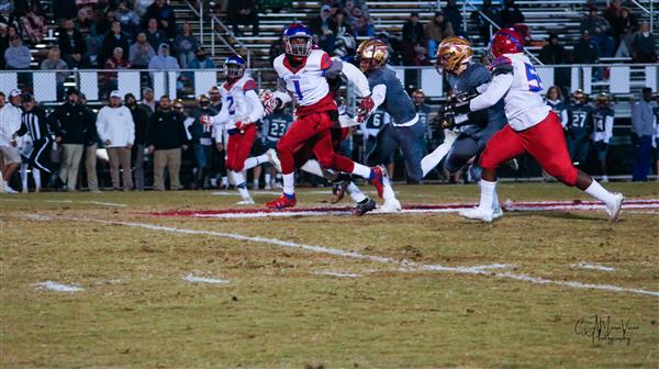 A dynamic moment in a college football game with players in action on the field.