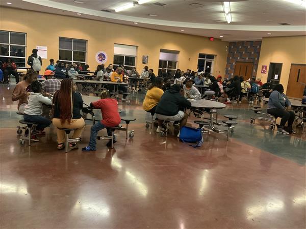 A school cafeteria bustling with students during lunchtime.