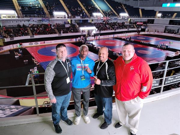 Friends and colleagues pose for a picture in the wrestling arena.