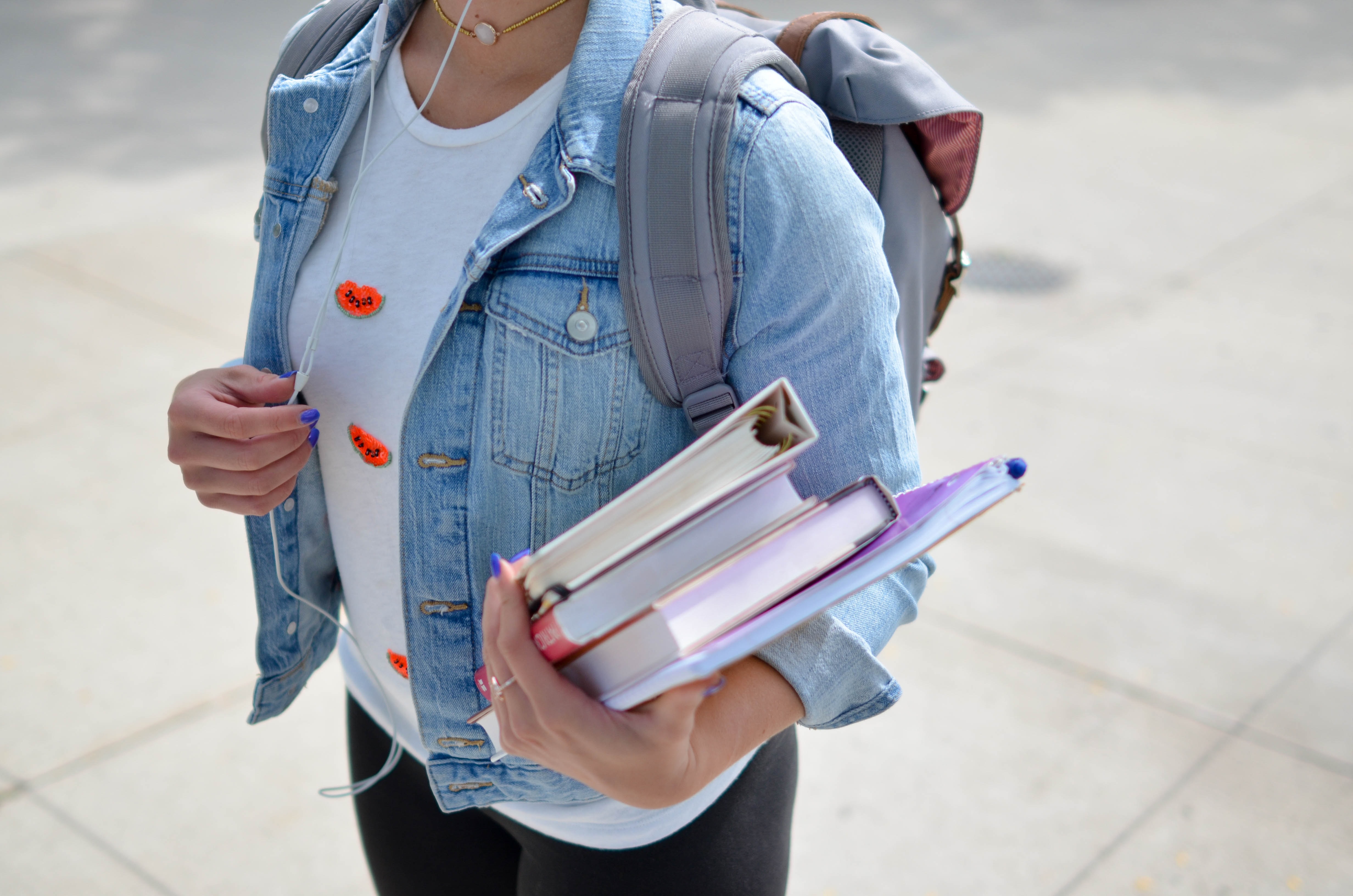 student with books and backpack