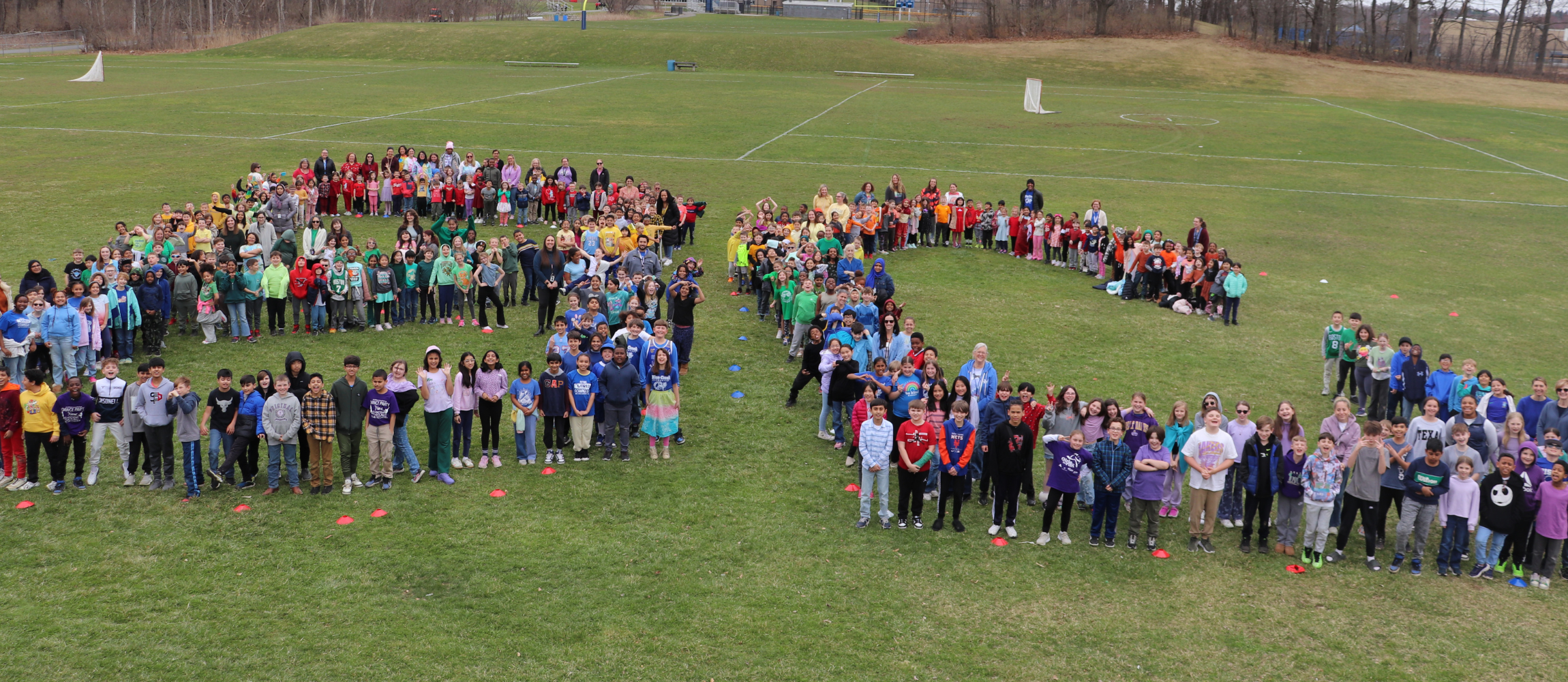 Students and faculty line up to spell out "BC" on the lawn outside of their school.