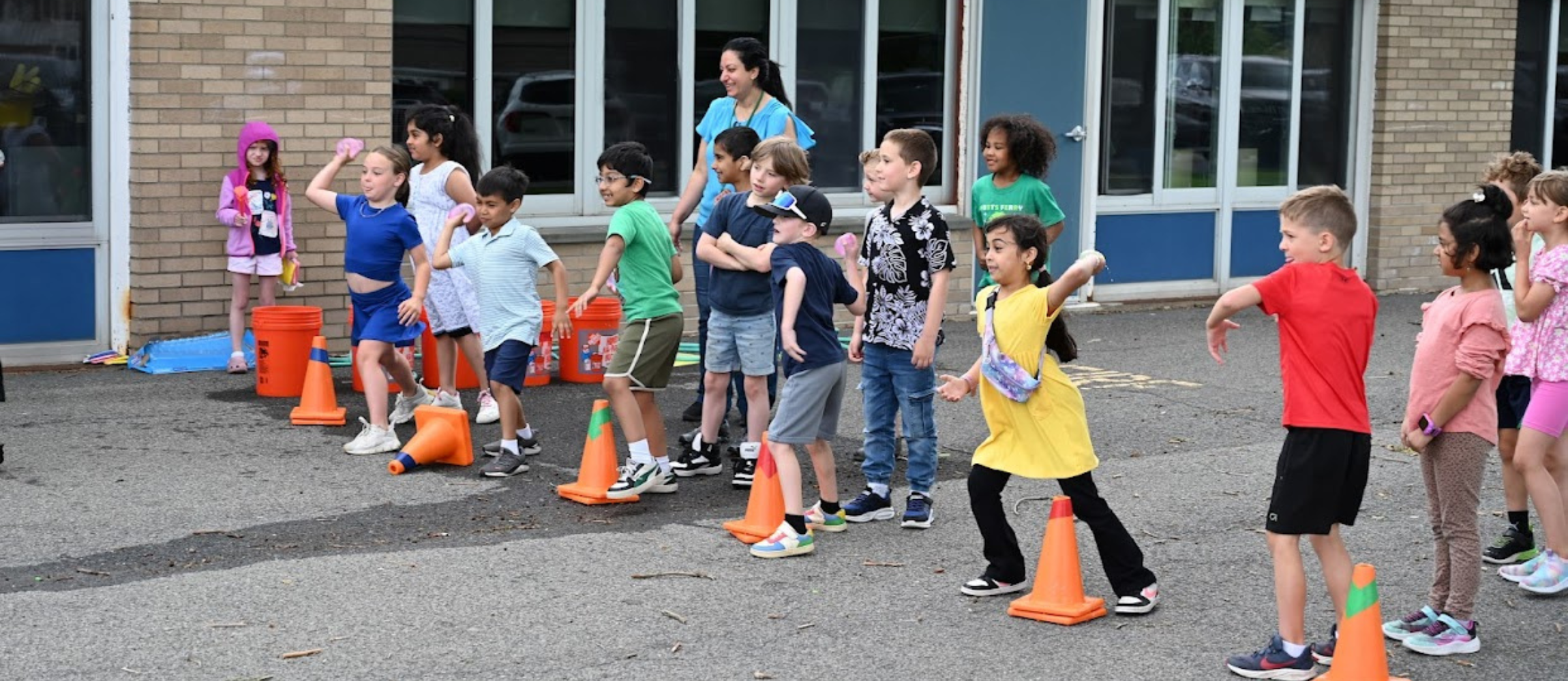 Forts Ferry first graders throwing water balloons at principal Dr. Casey Parker.
