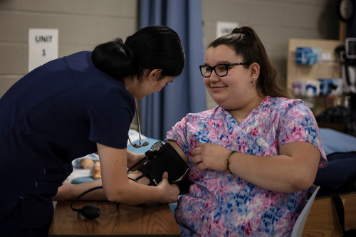 A student takes another student's blood pressure