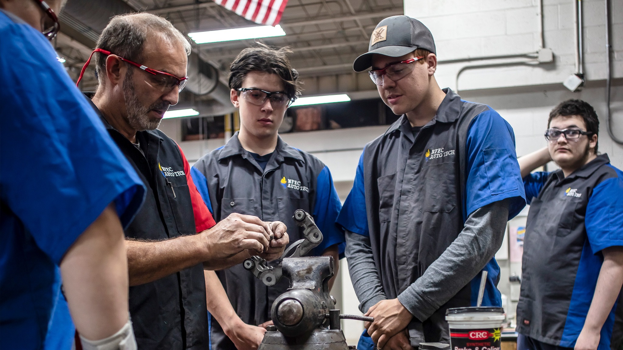 Students and instructor working on car part