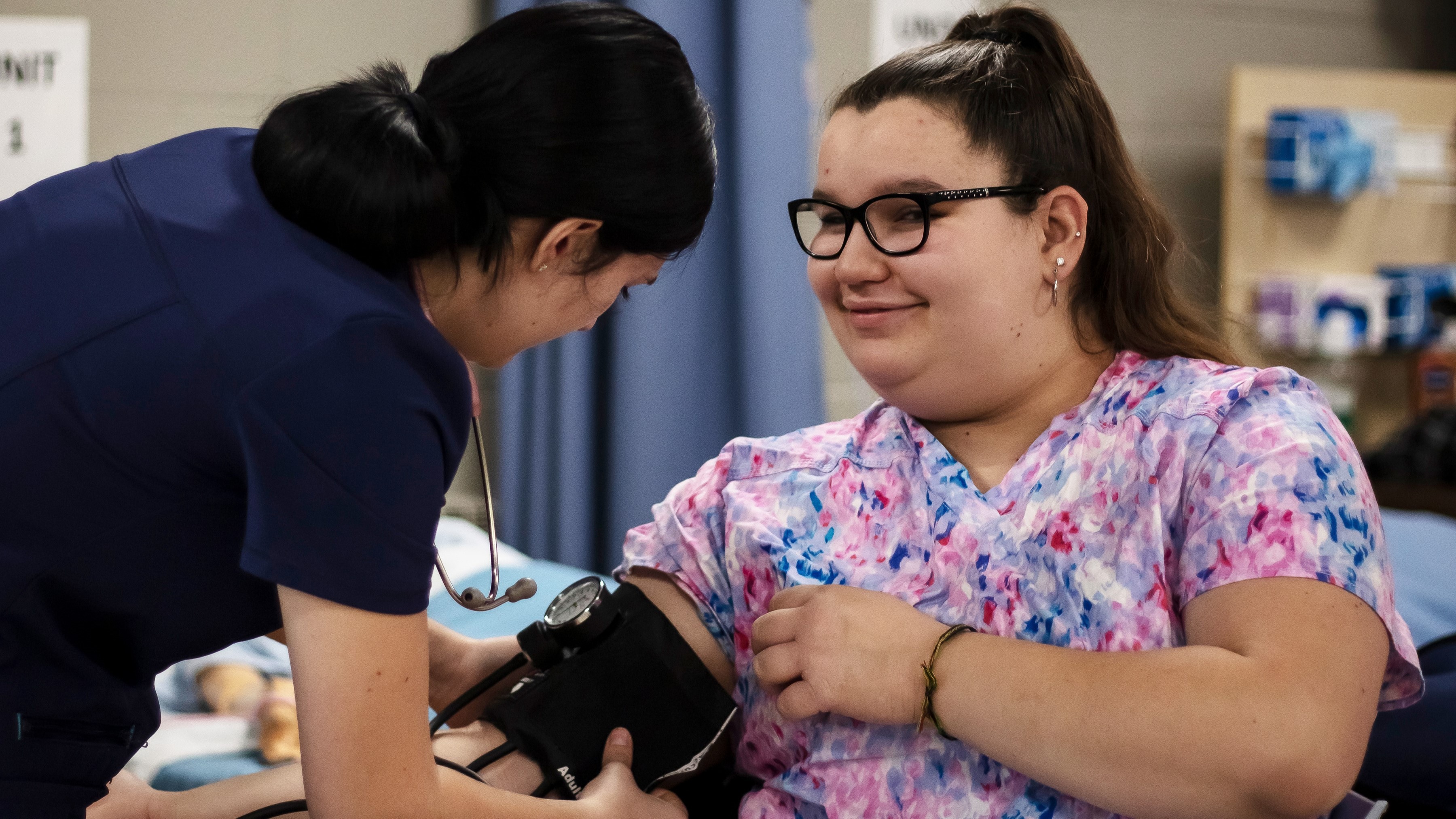 Student checking blood pressure of fellow student