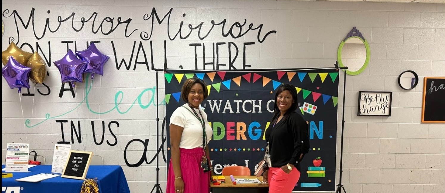 Mrs. Lewis and Dr. Sellers standing in front of a table welcoming parents to our Open House.