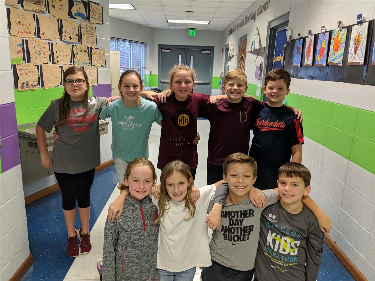 A group of students posing for a photo in the classroom hallway.