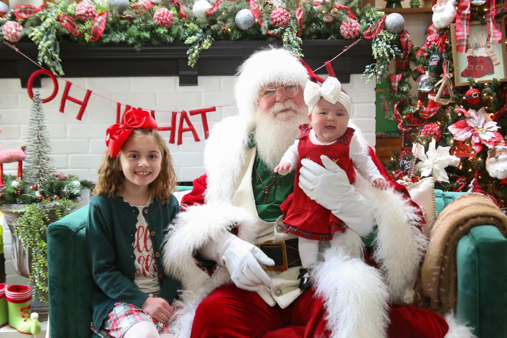 Santa Claus stands cheerfully in a holiday village