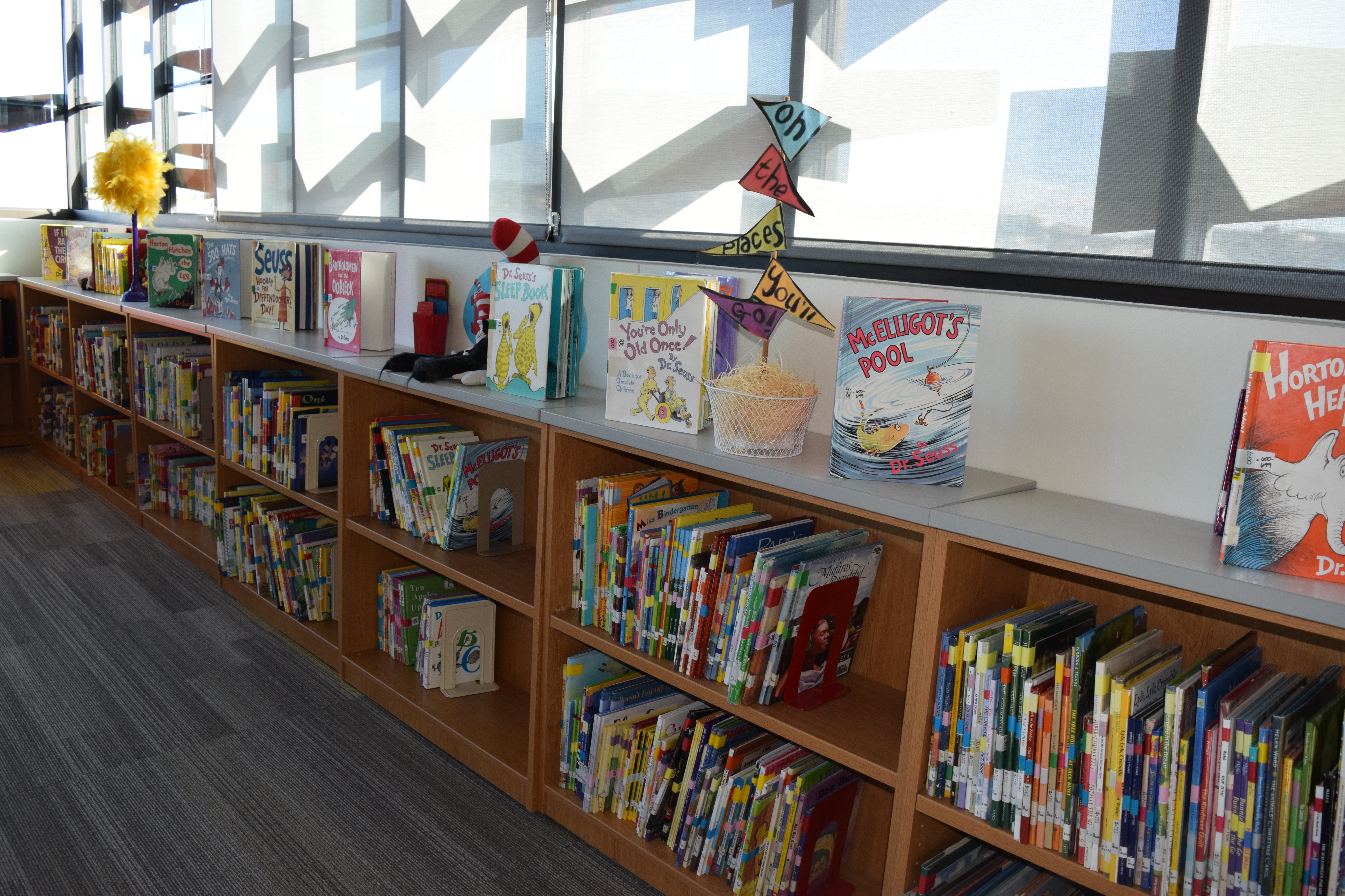 The school library, with Dr. Seuss books displayed on top of a row of bookshelves.